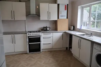 a kitchen with white cabinets and a stove top oven at Homely three bedroom in Vange