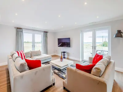 a living room with two couches and red pillows at Mals Barn in Althorne