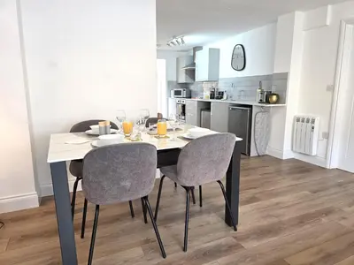 a dining room table and chairs in a kitchen at Modern One Bed Flat at Dawe Luxury Suites - An Entire Apartment near Ely Cathedral & Train Station - The Perfect Gateway to Explore Ely, Cambridge, Norfolk & London - Sleeps up to 4 in Ely