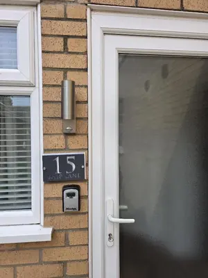 a door to a house with a clock next to it at Modern One Bed Flat at Dawe Luxury Suites - An Entire Apartment near Ely Cathedral & Train Station - The Perfect Gateway to Explore Ely, Cambridge, Norfolk & London - Sleeps up to 4 in Ely