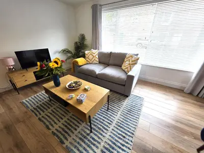a living room with a couch and a coffee table at Modern One Bed Flat at Dawe Luxury Suites - An Entire Apartment near Ely Cathedral & Train Station - The Perfect Gateway to Explore Ely, Cambridge, Norfolk & London - Sleeps up to 4 in Ely