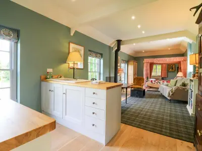 a kitchen with a counter and a living room at Clock Tower in Stowmarket