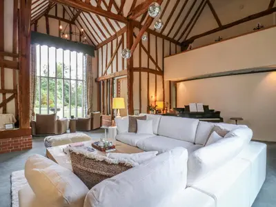 a large living room with white couches and a piano at Headland Barn in Maldon