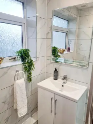 a white bathroom with a sink and a mirror at Chelmsford Getaway Business and Leisure