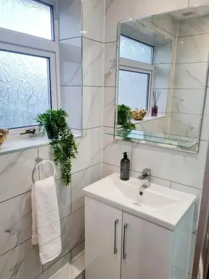 a white bathroom with a sink and a mirror at Chelmsford Getaway Business and Leisure