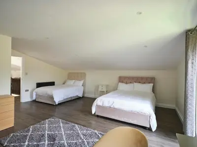 a bedroom with two beds and a rug at Whiskey Barns in Birch
