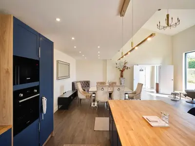 a kitchen and living room with a table and chairs at Whiskey Barns in Birch