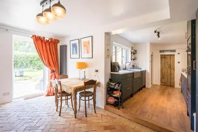 a kitchen with a table and a dining room at Farm View, ground floor bedroom in Kelsale
