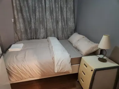 a small bed in a small room with a lamp at Stacey's Cozy Home in Basildon