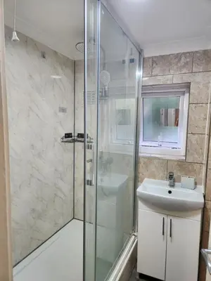 a bathroom with a shower and a sink at Stacey's Cozy Home in Basildon