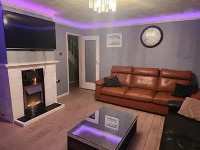 a living room with a couch and a fireplace at Stacey's Cozy Home in Basildon