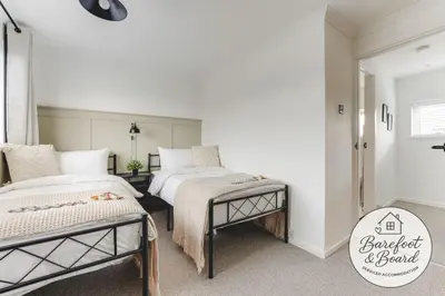 two beds in a bedroom with white walls at Luxury 2-Bed House in Stevenage Sleeps 6 Free Parking Barefoot & Board in Shephall