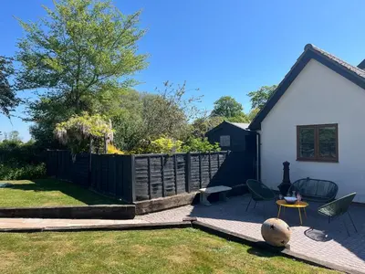 a backyard with a fence and a table and chairs at Cottage nestled in the heart of a stunning Suffolk Village in Chediston