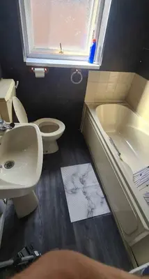 a bathroom with a sink and a toilet and a bath tub at Karan Lodge in Mildenhall