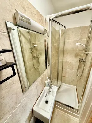 a bathroom with a shower and a sink and a mirror at Beautiful Modern 2 Bed house combined with a vintage feel near Central Cambridge Sleeps 4 in Cambridge