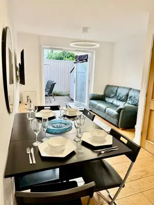 a black dining room table with chairs and a couch at Beautiful Modern 2 Bed house combined with a vintage feel near Central Cambridge Sleeps 4 in Cambridge