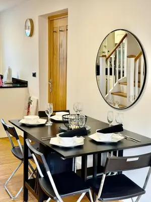 a dining room with a black table and a mirror at Beautiful Modern 2 Bed house combined with a vintage feel near Central Cambridge Sleeps 4 in Cambridge