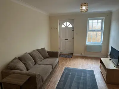 a living room with a couch and a tv at Ely Stays Flat 2 in Ely
