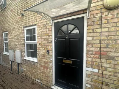 a black door on the side of a brick building at Ely Stays Flat 2 in Ely