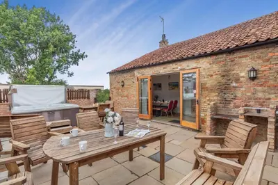 a patio with a wooden table and wooden chairs at 6 Bed in Three Holes oc-t31855 in Upwell
