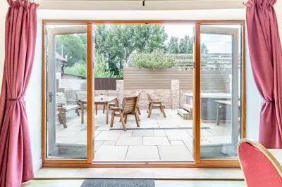 a patio with sliding glass doors and a table and chairs at 6 Bed in Three Holes oc-t31855 in Upwell