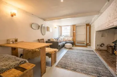 a living room with a table and a couch at Charming 2BR Cottage in Orford