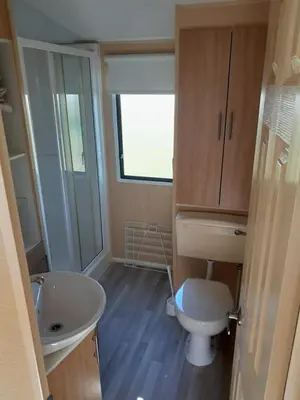 a small bathroom with a toilet and a sink at Comfortable and Spacious Mobile home - Sleeps 6, in Clacton-on-Sea