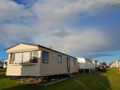 a mobile home is parked in a yard at Comfortable and Spacious Mobile home - Sleeps 6, in Clacton-on-Sea