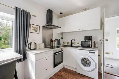 a kitchen with a washing machine and a washer at Rosabelle in Wivenhoe