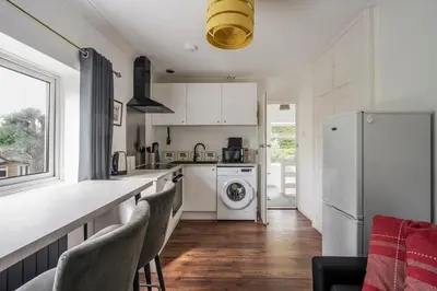 a kitchen with a white refrigerator and a dishwasher at Rosabelle in Wivenhoe