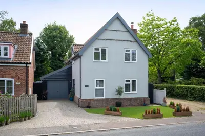 a white house with a garden in front of it at Detached House in Quiet Village - Pets Allowed in Ipswich