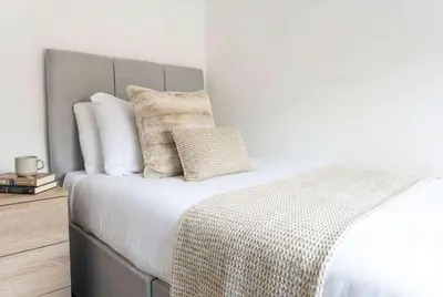 a bedroom with a bed with white sheets and pillows at Modern 3 Bedroom Home with Parking in Southend in Southend-on-Sea