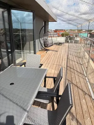 a deck with a table and chairs on a boat at The Opulent Property Project Penthouse Chelmsford 2 Bed 2 Bath Sleeps 6 Free Parking 2 Kings or 4 singles and Double Sofabed Ideal for long stays, corporates, families, Insurance in Chelmsford