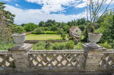 a stone fence with a garden in the background at Holbecks House by Group Retreats in Hadleigh