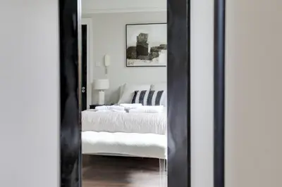 a bedroom with a white bed and a mirror at Cambridge City Centre by Luxiety Stays Stylish Rooms, Prime Location & Wi-Fi in Cambridge