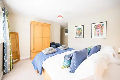 a bedroom with a large white bed with blue pillows at Woodland Lodge, Aldeburgh in Aldeburgh