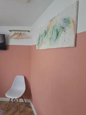 a room with a white chair and a painting on the wall at Whole Annexe in our family home & private entrance in Ipswich