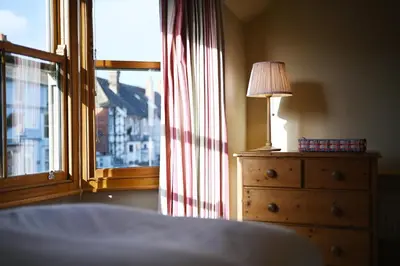 a bedroom with a window and a lamp on a dresser at Pilots House Aldeburgh in Aldeburgh
