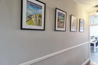 a hallway with four pictures on the wall at The Opulent Property Project Southend Beach House Sleeps 8 Free Parking x 2 Perfect for Contractors 4 King Beds or 8 Single Beds in Southend-on-Sea
