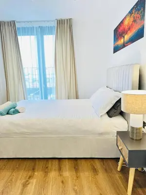 a bedroom with a bed and a table with a lamp at Gorgeous two bedroom luxury Apartment sleeps 6 in Brentwood
