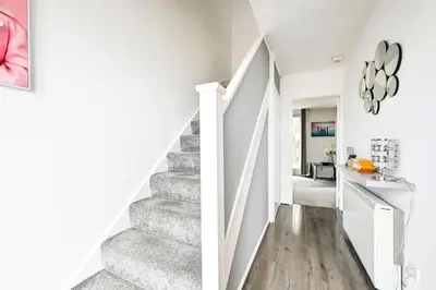 a staircase in a home with white walls and wood floors at Modern 3-Bed Maisonette - Epping High Street - Parking - LMV Property in Epping