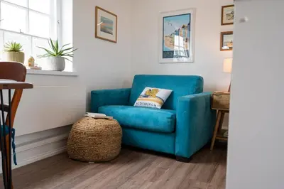 a blue couch in a living room with a table at The Loft, Bungay in Bungay