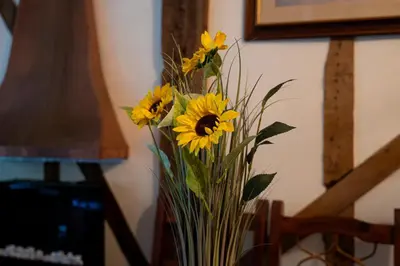 a vase filled with yellow flowers sitting on a table at Group Stays 600-Year-Old Barn, sleeps 11 in Great Parndon