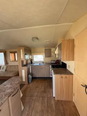 a small kitchen with wooden cabinets and a counter top at Singh&Leite Family L6 in Saint Osyth