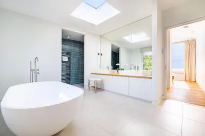 a white bathroom with a tub and a sink at Heath House 8 in Thorpeness