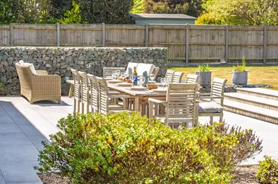 a patio with a table and chairs and a fence at Heath House 8 in Thorpeness