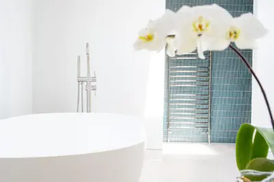 a bathroom with a view of the shard and white flowers at Heath House 6 in Thorpeness