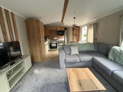 a living room with a couch and a tv at The Orchards modern caravan in Saint Osyth