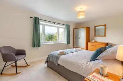 a bedroom with a bed and a chair and a window at 5 Bed in Washbrook oc-m33105 in Hintlesham