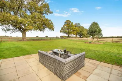 an outdoor seating area with a field and trees at 5 Bed in Washbrook oc-m33105 in Hintlesham